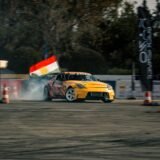 Comisar de traseu care flutură un steag galben lângă pista unui circuit de curse