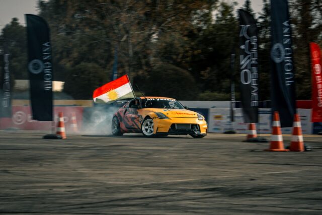 Comisar de traseu care flutură un steag galben lângă pista unui circuit de curse